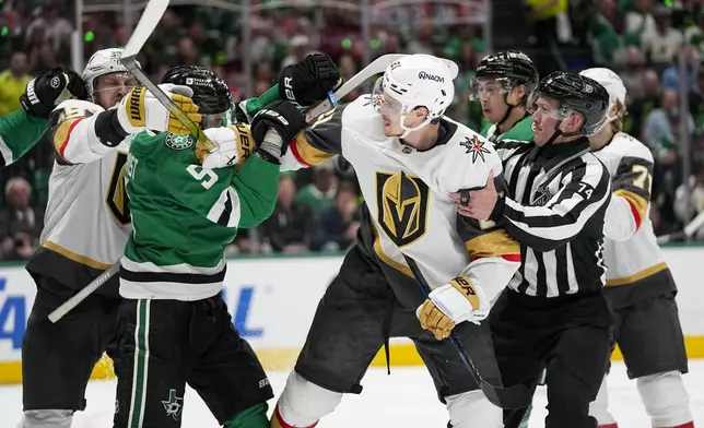 NHL linesman Trent Knorr (74) and players try to intervene as Dallas Stars defenseman Nils Lundkvist (5) and Vegas Golden Knights center Brett Howden (21) get tangled up during the second period in Game 2 of an NHL hockey Stanley Cup first-round playoff series in Dallas, Wednesday, April 24, 2024. (AP Photo/Tony Gutierrez)