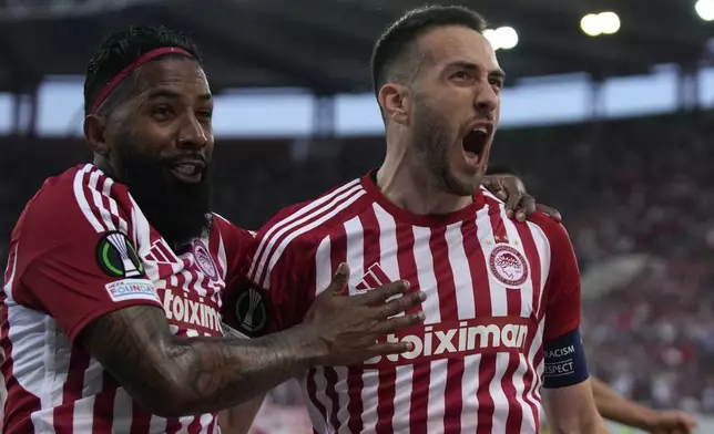 Olympiaco's Kostas Fortounis, right, celebrates with his teammate Olympiacos' Rodinei after scoring against Fenerbahce during the Europa Conference League quarter final first leg soccer match between Olympiacos and Fenerbahce at the Georgios Karaiskakis stadium, Piraeus port near Athens, Greece, Thursday, April 11, 2024. (AP Photo/Thanassis Stavrakis)