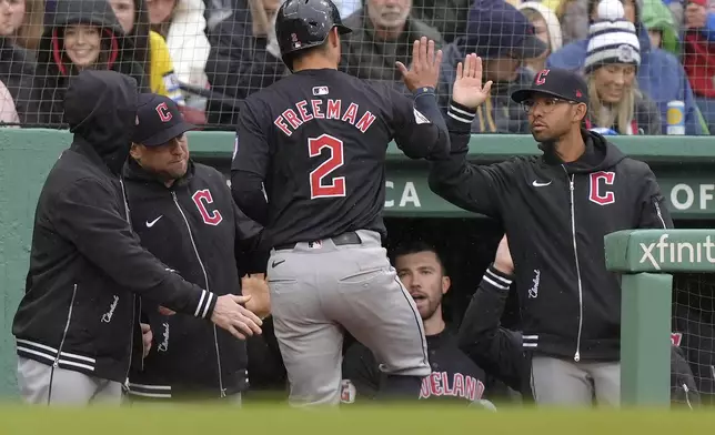 Cleveland Guardians' Tyler Freeman (2) is welcomed to the dugout after scoring on a single by Ramón Laureano in the sixth inning of a baseball game against the Boston Red Sox, Thursday, April 18, 2024, in Boston. (AP Photo/Steven Senne)