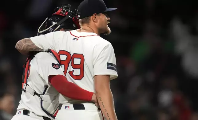 Boston Red Sox pitcher Tanner Houck (89) is embraced by catcher Connor Wong after Houck threw a three-hitter against the Cleveland Guardians in a baseball game Wednesday, April 17, 2024, in Boston. (AP Photo/Charles Krupa)
