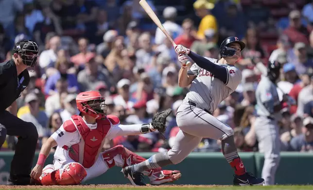 Cleveland Guardians' Will Brennan follows through on his two-run home run in front of Boston Red Sox catcher Reese McGuire during the seventh inning of a baseball game, Monday, April 15, 2024, in Boston. (AP Photo/Michael Dwyer)