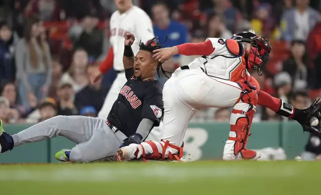 Cleveland Guardians' José Ramírez, left, scores on a single by Estevan Florial, next to Boston Red Sox's Connor Wong during the 11th inning of a baseball game Tuesday, April 16, 2024, in Boston. (AP Photo/Steven Senne)