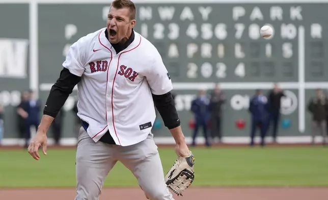 Former New England Patriots NFL football player Rob Gronkowski reacts after spiking the ball instead of throwing it during the ceremonial first pitch before a baseball game between the Boston Red Sox and the Cleveland Guardians, Monday, April 15, 2024, in Boston. (AP Photo/Michael Dwyer)