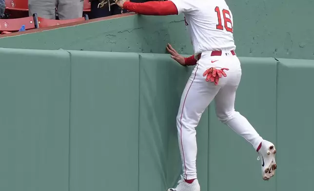 Boston Red Sox's Jarren Duran (16) leaps to the stands while reaching for a fly ball by Cleveland Guardians' Brayan Rocchio, that was foul, in the third inning of a baseball game, Thursday, April 18, 2024, in Boston. The ball (AP Photo/Steven Senne)
