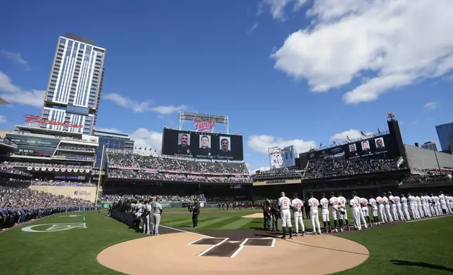 A moment of silence is held for the Burnsville First Responders killed in the line of duty last month before the Minnesota Twins' home opener baseball game against the Cleveland Guardians, Thursday, April 4, 2024, in Minneapolis. (AP Photo/Abbie Parr)