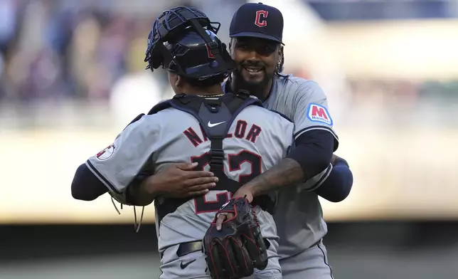 Cleveland Guardians catcher Bo Naylor (23) and relief pitcher Emmanuel Clase, right, hug after their win over the Minnesota Twins of a baseball game Thursday, April 4, 2024, in Minneapolis. (AP Photo/Abbie Parr)