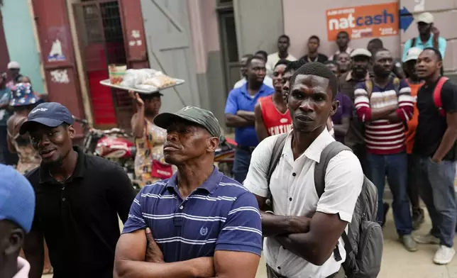 Men watch a soccer match televised in a shop in Cap-Haitien, Haiti, Wednesday, April 17, 2024. (AP Photo/Ramon Espinosa)
