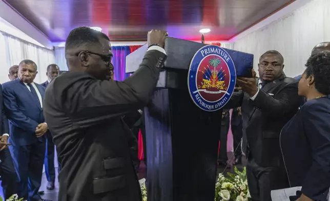 Officials set up the podium before the the swearing-in ceremony of the transitional council tasked with selecting Haiti's new prime minister and cabinet, in Port-au-Prince, Haiti, Thursday, April 25, 2024. (AP Photo/Ramon Espinosa)
