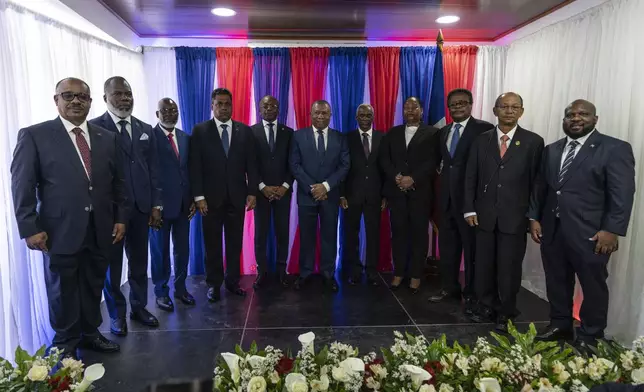 Interim Prime Minister Michel Patrick Boisvert, fifth from left, poses for a group photo with members of a transitional council tasked with selecting a new prime minister and cabinet, in Port-au-Prince, Haiti, Thursday, April 25, 2024. (AP Photo/Ramon Espinosa)