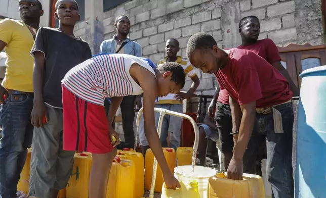 FILE - Residents fill their containers with potable water, in Port-au-Prince, Haiti, March 8, 2024. (AP Photo/Odelyn Joseph, File)
