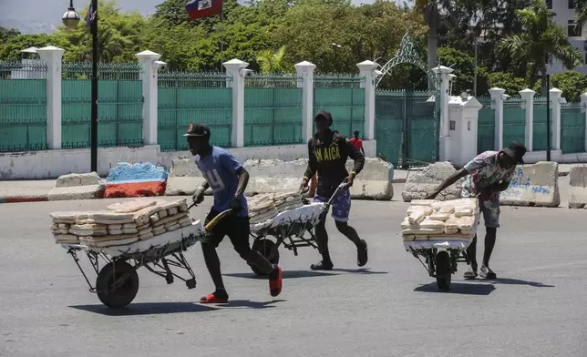 FILE - Street vendors withdraw from the area where they were selling their bread, near the National Palace, in Port-au-Prince, Haiti, April 2, 2024. (AP Photo/Odelyn Joseph, File)