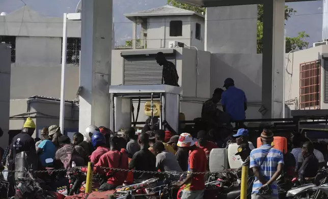 FILE - People crowd around a fuel pump at a gas station in Port-au-Prince, Haiti, April 6, 2024. (AP Photo/Odelyn Joseph, File)
