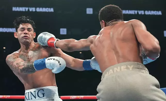 Devin Haney, right, punches Ryan Garcia during the second round of a super lightweight boxing match early Sunday, April 21, 2024, in New York. (AP Photo/Frank Franklin II)