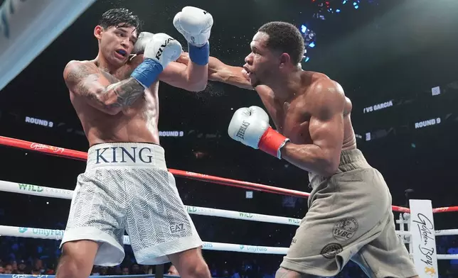 Devin Haney, right, punches Ryan Garcia during the ninth round of a super lightweight boxing match early Sunday, April 21, 2024, in New York. Garcia won the fight. (AP Photo/Frank Franklin II)