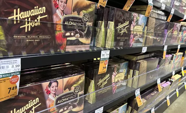 Packages of macadamia nuts are displayed on store shelves on Friday, April 26, 2024, in Honolulu. For decades, tourists to Hawaii have brought home gift boxes of the islands' famous chocolate-covered macadamia nuts for friends and family. (AP Photo/Audrey McAvoy)