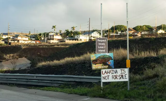 FILE - Signs asking people to respect locals and that "Lahaina is not for sale" are seen on the side of the Lahaina Bypass, Wednesday, Dec. 6, 2023, in Lahaina, Hawaii. An acute housing shortage hitting fire survivors on the Hawaiian island of Maui is squeezing out residents even as they try to overcome the loss of loved ones, their homes and their community. (AP Photo/Lindsey Wasson, File)