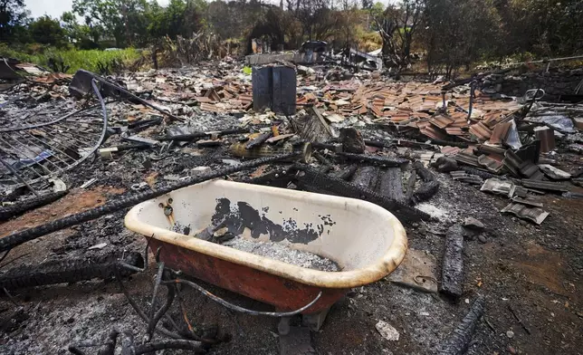 FILE - A tub rests in the middle of a wildfire-destroyed home, Monday, Aug. 14, 2023, in Kula, Hawaii. The Maui Fire Department is expected to release a report Tuesday, April 16, 2024, detailing how the agency responded to a series of wildfires that burned on the island during a windstorm last August. (AP Photo/Rick Bowmer, File)