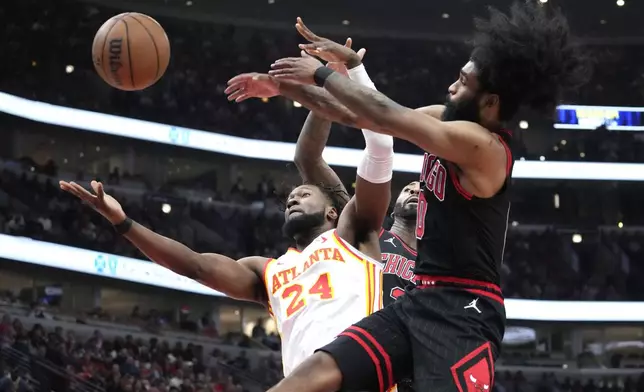 Atlanta Hawks forward Bruno Fernando (24) and Chicago Bulls guard Coby White, right, and center Andre Drummond vie for a rebound during the first half of an NBA basketball play-in tournament game in Chicago, Wednesday, April 17, 2024. (AP Photo/Nam Y. Huh)