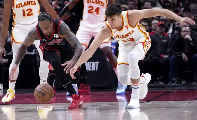 Chicago Bulls forward DeMar DeRozan, left, and Atlanta Hawks guard Bogdan Bogdanovic reach for the ball during the first half of an NBA basketball play-in tournament game in Chicago, Wednesday, April 17, 2024. (AP Photo/Nam Y. Huh)
