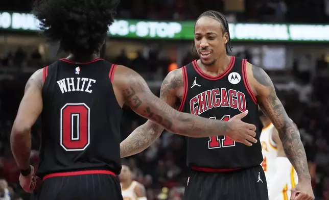 Chicago Bulls guard Coby White, left, celebrates with forward DeMar DeRozan after scoring against the Atlanta Hawks during the second half of an NBA basketball play-in tournament game in Chicago, Wednesday, April 17, 2024. The Bulls won 131-116. (AP Photo/Nam Y. Huh)