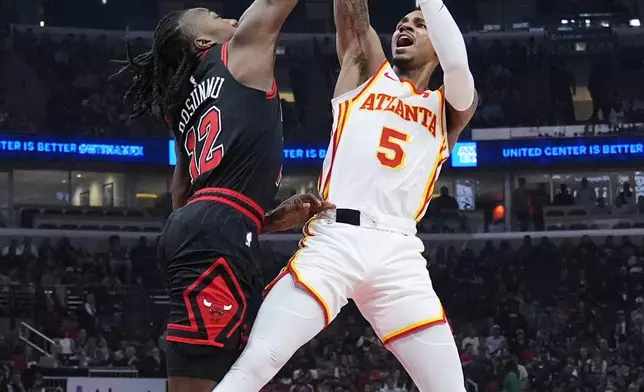 Chicago Bulls guard Ayo Dosunmu, left, blocks a shot by Atlanta Hawks guard Dejounte Murray during the first half of an NBA basketball play-in tournament game in Chicago, Wednesday, April 17, 2024. (AP Photo/Nam Y. Huh)