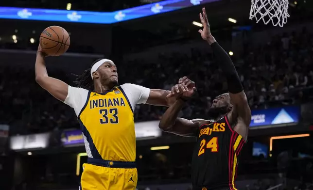 Indiana Pacers center Myles Turner (33) shoots over Atlanta Hawks forward Bruno Fernando (24) during the second half of an NBA basketball game in Indianapolis, Sunday, April 14, 2024. (AP Photo/Michael Conroy)