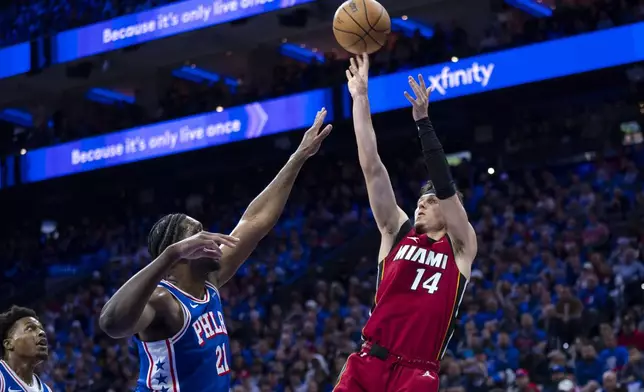 Miami Heat's Tyler Herro, right, shoots over Philadelphia 76ers' Joel Embiid during the first half of an NBA basketball play-in tournament game, Wednesday, April 17, 2024, in Philadelphia. (AP Photo/Chris Szagola)