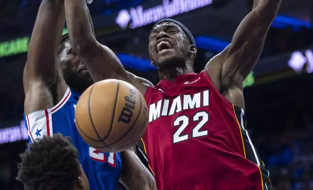 Miami Heat's Jimmy Butler, right, reacts to a foul by Philadelphia 76ers' Kyle Lowry, lower left, while going up for a shot during the first half of an NBA basketball play-in tournament game Wednesday, April 17, 2024, in Philadelphia. (AP Photo/Chris Szagola)