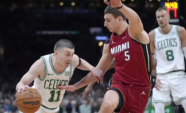 Boston Celtics guard Payton Pritchard (11) drives toward the basket as Miami Heat forward Nikola Jovic (5) defends in the first half of Game 1 of an NBA basketball first-round playoff series, Sunday, April 21, 2024, in Boston. (AP Photo/Steven Senne)