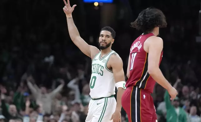 Boston Celtics forward Jayson Tatum (0) celebrates in front of Miami Heat guard Jaime Jaquez Jr. (11) as the Celtics lead in the first half of Game 1 of an NBA basketball first-round playoff series, Sunday, April 21, 2024, in Boston. (AP Photo/Steven Senne)
