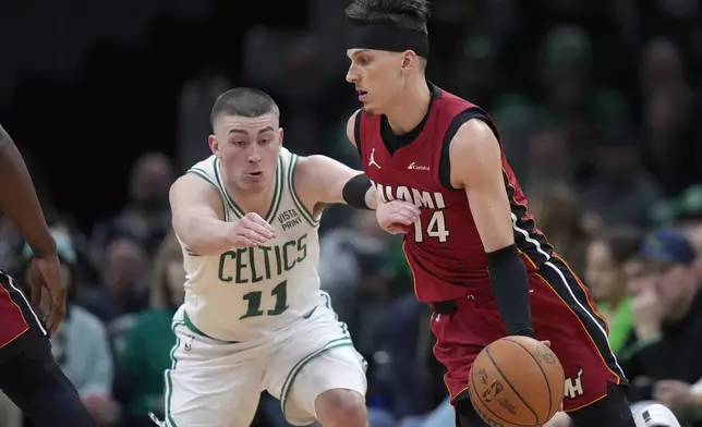 Miami Heat guard Tyler Herro (14) drives as Boston Celtics guard Payton Pritchard (11) defends in the first half of Game 1 of an NBA basketball first-round playoff series, Sunday, April 21, 2024, in Boston. (AP Photo/Steven Senne)