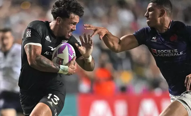 New Zealand's Moses Leo is tackled by Aaron Grandidier Nkanang from France during the men's final match in the Hong Kong Sevens rugby tournament in Hong Kong, Sunday, April 7, 2024. (AP Photo/Louise Delmotte)