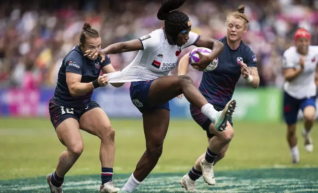Seraphine Okemba, center, of France is tackled by Kristi Kirshe of the United States during the women semifinal match in the Hong Kong Sevens rugby tournament in Hong Kong, Sunday, April 7, 2024. (AP Photo/Louise Delmotte)