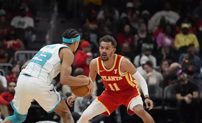 Charlotte Hornets guard Tre Mann (23) moves against Atlanta Hawks guard Trae Young (11) during the second half of an NBA basketball game, Wednesday, April 10, 2024, in Atlanta. (AP Photo/Mike Stewart)