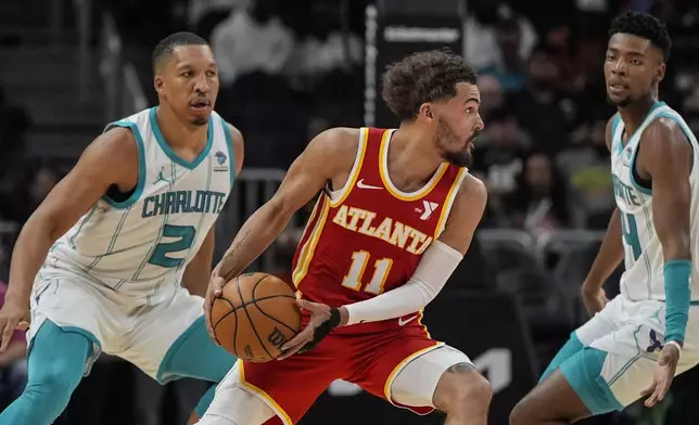 Atlanta Hawks guard Trae Young (11) moves the ball against the Charlotte Hornets during the first half of an NBA basketball game, Wednesday, April 10, 2024, in Atlanta. (AP Photo/Mike Stewart)