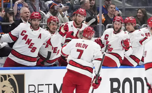 Carolina Hurricanes' Dmitry Orlov (7) is congratulated for his goal against the New York Islanders during the first period of Game 3 of an NHL hockey Stanley Cup first-round playoff series Thursday, April 25, 2024, in Elmont, N.Y. (AP Photo/Frank Franklin II)