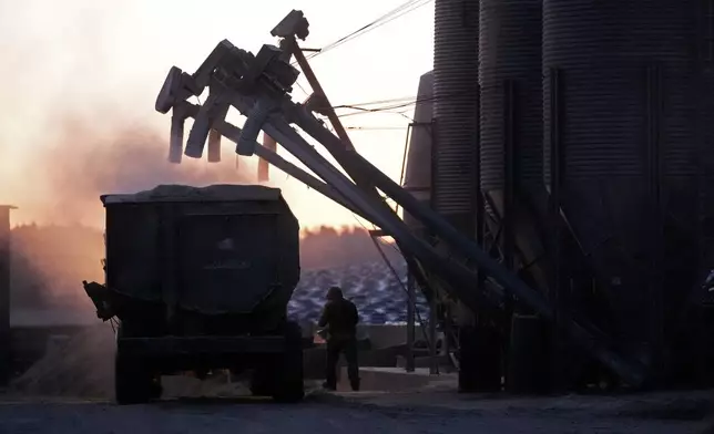 A feed truck is loaded at dawn at the Flood Brothers Farm, Monday, April 1, 2024, in Clinton, Maine. Foreign-born workers make up fully half the farm's staff of nearly 50, feeding the cows, tending crops and helping collect the milk — 18,000 gallons every day. (AP Photo/Robert F. Bukaty)