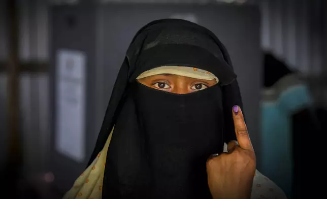 A woman shows the indelible ink mark on her finger after casting vote in a polling station on the bank of the Brahmaputra river during the second round of voting in the six-week-long national election in Morigaon district, India, Friday, April 26, 2024. (AP Photo/Anupam Nath)