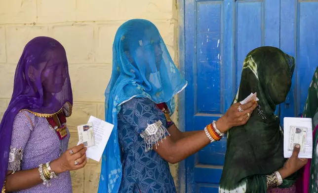 Women queue up to cast their vote during the second phase of polling in the six-week long national election in Barmer district, western Rajasthan state, India, Friday, April 26, 2024. (AP Photo/Deepak Sharma)