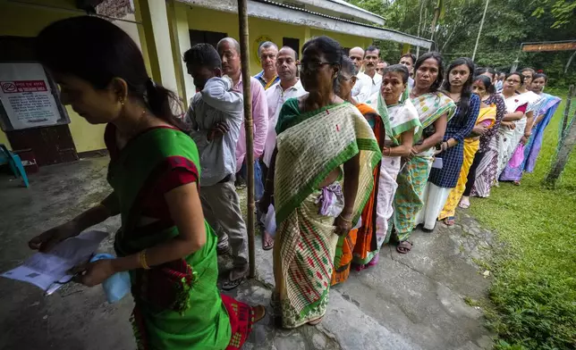 People stand in queue to cast their votes during the first round of polling of India's national election in Bahona village, Jorhat, northeastern Assam, India, Friday, April 19, 2024. Nearly 970 million voters will elect 543 members for the lower house of Parliament for five years, during staggered elections that will run until June 1. (AP Photo/Anupam Nath)