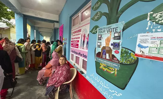 Women wait up to cast their votes during the first round of polling of India’s national election in Doda district, Jammu and Kashmir, India, Friday, April 19, 2024. (AP Photo/Channi Anand)