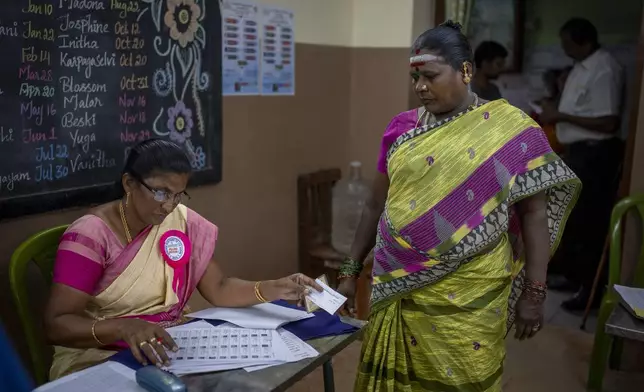 A woman, right, arrives to cast her vote during the first round of polling of India’s national election in Chennai, southern Tamil Nadu state, Friday, April 19, 2024. Nearly 970 million voters will elect 543 members for the lower house of Parliament for five years, during staggered elections that will run until June 1. (AP Photo/Altaf Qadri)