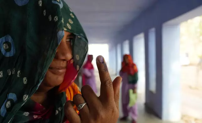 A woman shows the indelible ink mark on her index finger after voting during the first round of polling of India's national election in Neemrana, Rajasthan state, India, Friday, April 19, 2024. Nearly 970 million voters will elect 543 members for the lower house of Parliament for five years, during staggered elections that will run until June 1. (AP Photo/Manish Swarup)