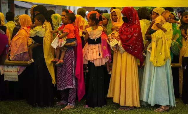 Women hold their babies as they queue up to cast their votes in a polling station on the bank of the Brahmaputra river during the second round of voting in the six-week-long national election in Morigaon district, Assam, India, Friday, April 26, 2024. (AP Photo/Anupam Nath)