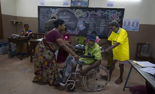 A voter on a wheelchair is assisted by others during the first round of polling of India’s national election in Chennai, southern Tamil Nadu state, Friday, April 19, 2024. Nearly 970 million voters will elect 543 members for the lower house of Parliament for five years, during staggered elections that will run until June 1. (AP Photo/Altaf Qadri)
