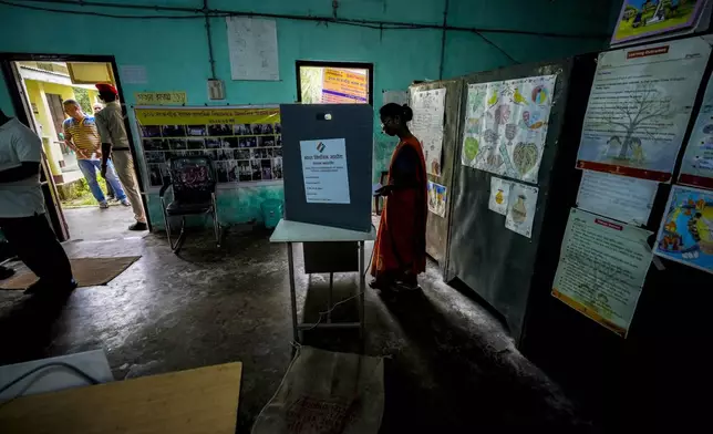 A woman casts vote during the first round of polling of India's national election in Bahona village, Jorhat, northeastern Assam, India, Friday, April 19, 2024. Nearly 970 million voters will elect 543 members for the lower house of Parliament for five years, during staggered elections that will run until June 1. (AP Photo/Anupam Nath)