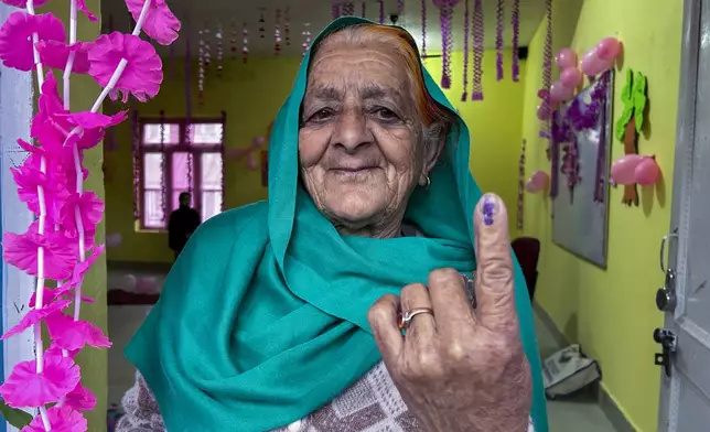 A woman shows the indelible ink mark on her finger after casting vote during the first round of polling of India’s national election in Doda district, Jammu and Kashmir, India, Friday, April 19, 2024. (AP Photo/Channi Anand)