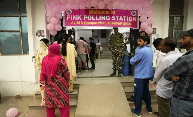 People wait in a queue at a Pink Polling Station, where all the polling officials are women, to cast their vote during the first round of polling of India's national election in Udhampur, Jammu and Kashmir, India, Friday, April 19, 2024. Nearly 970 million voters will elect 543 members for the lower house of Parliament for five years, during staggered elections that will run until June 1. (AP Photo/Channi Anand)