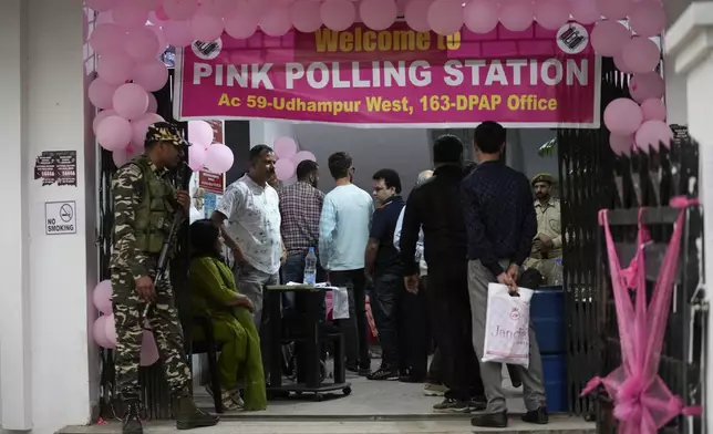 People wait in a queue at a Pink Polling Station, where all the polling officials are women, to cast their vote during the first round of polling of India's national election in Udhampur, Jammu and Kashmir, India, Friday, April 19, 2024. Nearly 970 million voters will elect 543 members for the lower house of Parliament for five years, during staggered elections that will run until June 1. (AP Photo/Channi Anand)