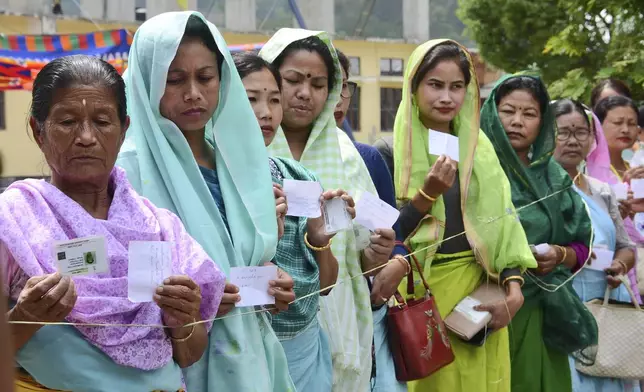 Women show their identity cards and voting slips as they stand in a queue to cast their vote during the first round of polling of India's national election in Bishnupur constituency on the outskirts of Imphal, Manipur, India, Friday, April 19, 2024. Nearly 970 million voters will elect 543 members for the lower house of Parliament for five years, during staggered elections that will run until June 1. (AP Photo/Bullu Raj)